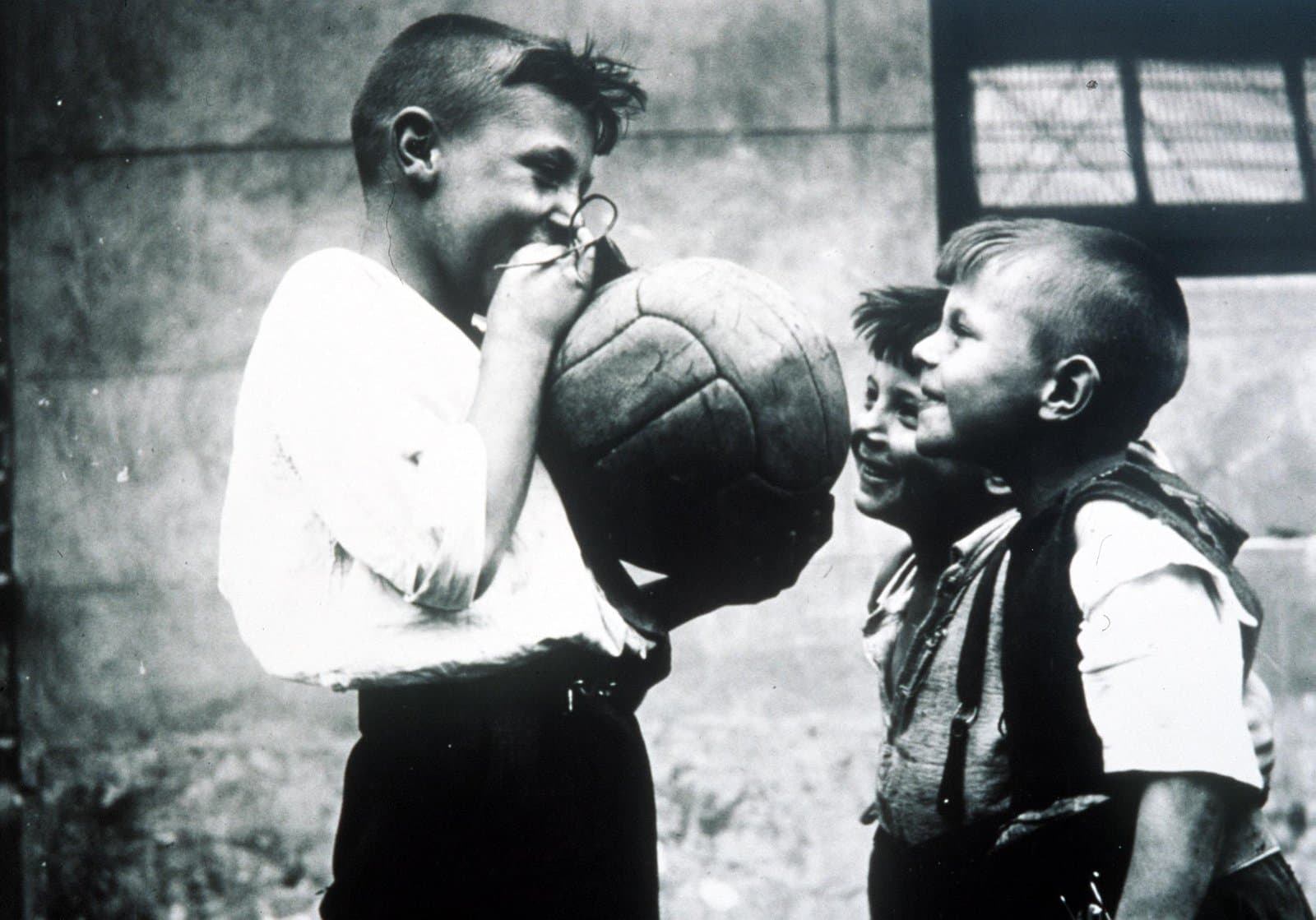 Meninos jogando futebol nos anos 50